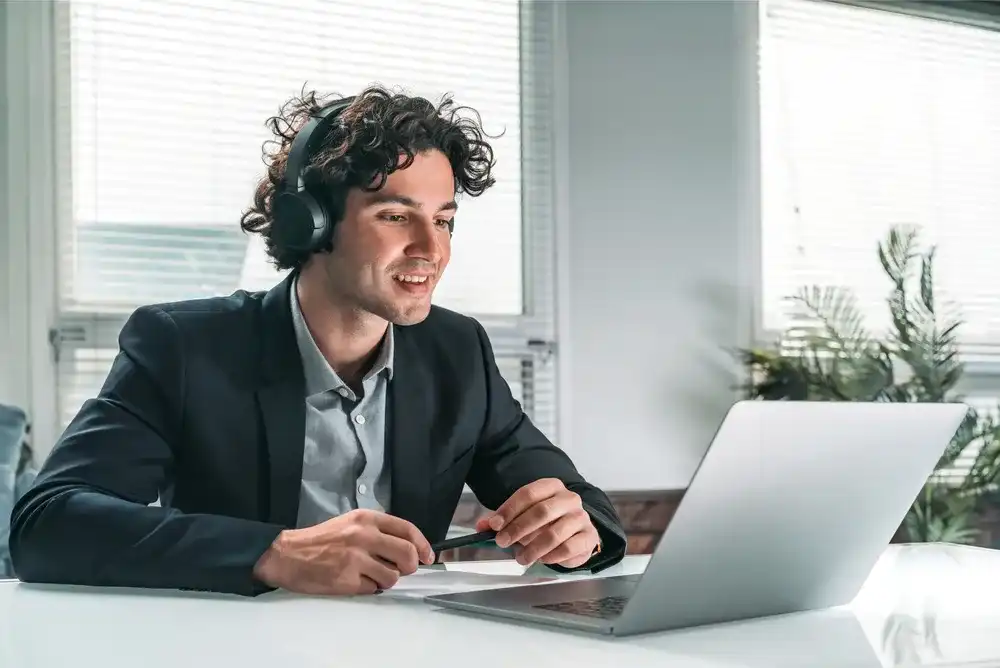 Man listening to a 2024 top financial podcast on his laptop
