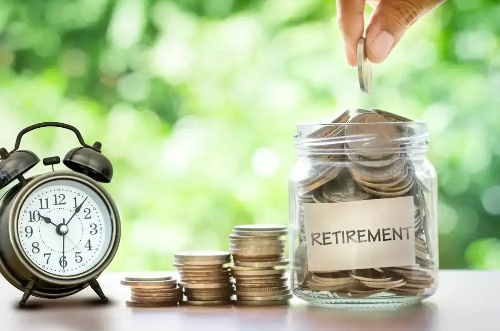 Someone placing money into a jar that says retirement