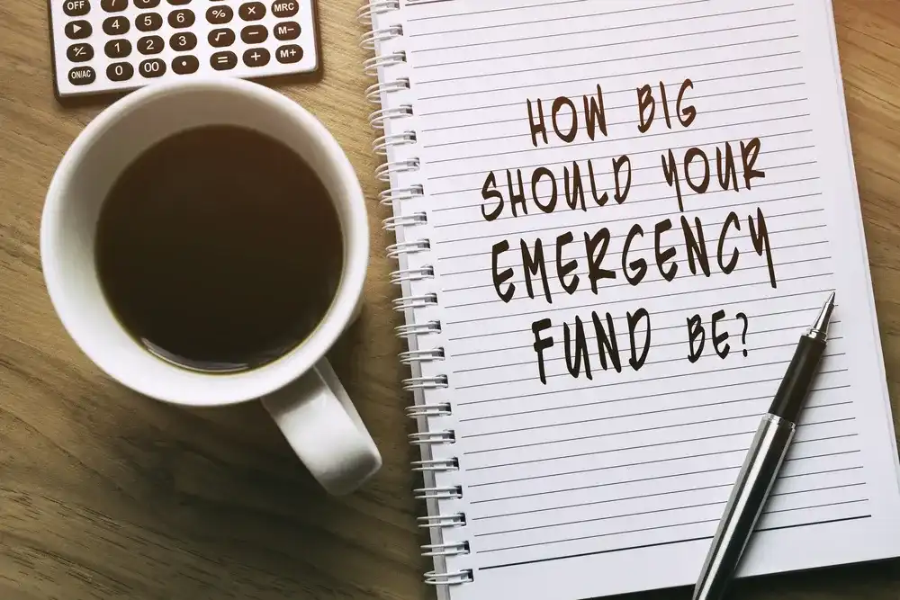 A notebook that reads " How Big Should Your Emergency Fund Be?"