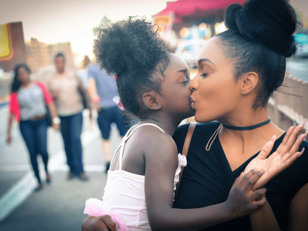 mother and daughter kissing each other cheeks