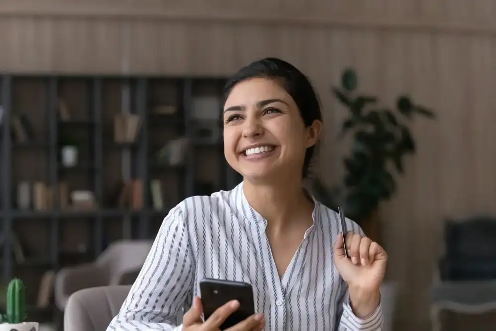 A woman shopping on her phone with a prepaid debit card