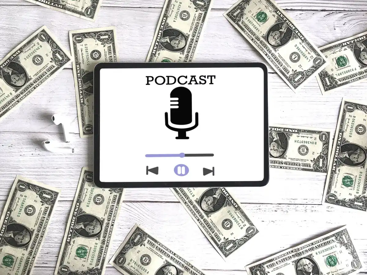 Podcast on a tablet with money scattered around