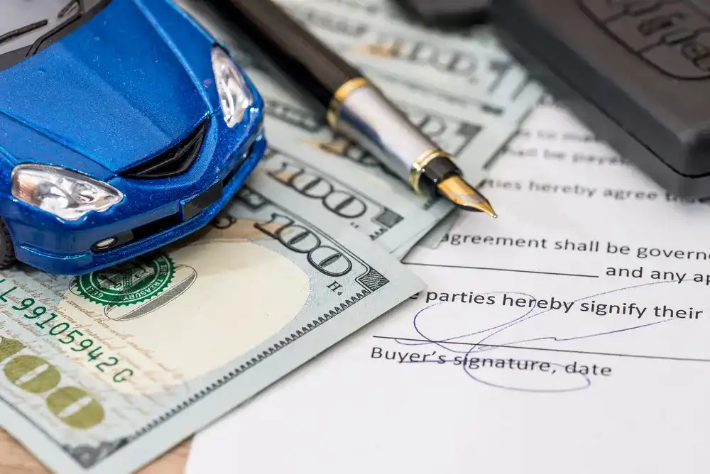Toy car and cash atop a loan with a car used as collateral