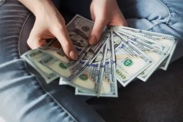 Someone holding $100 bills