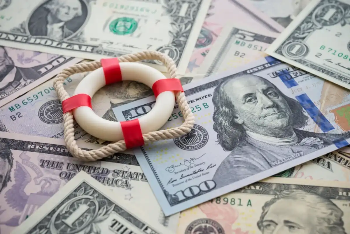 A life raft atop a pile of $100 bills
