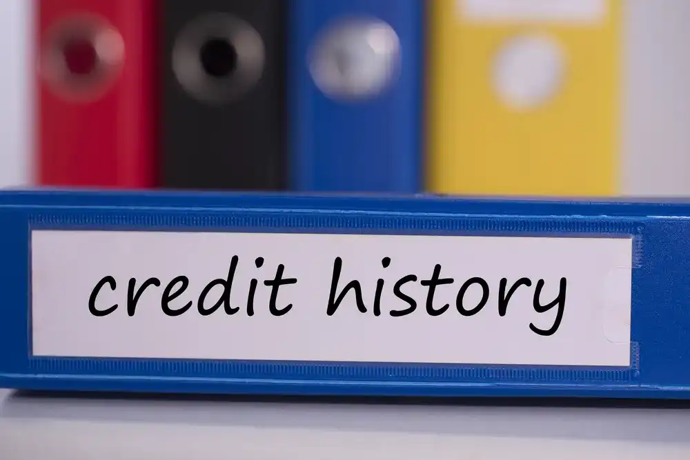A binder that reads "Credit History", part of a loan requirement