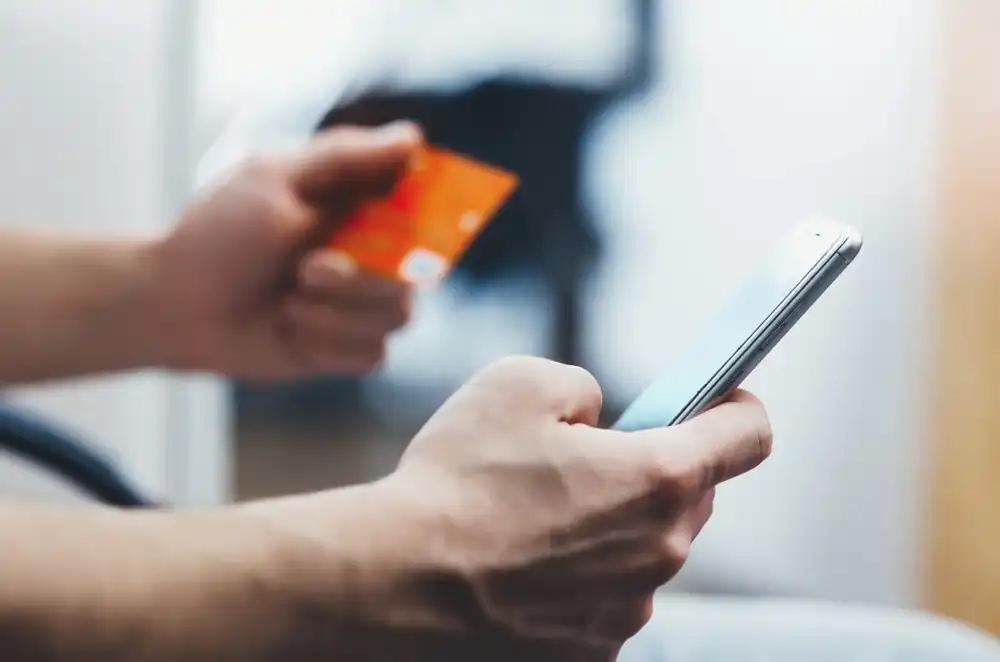 Someone using their credit card online on their phone