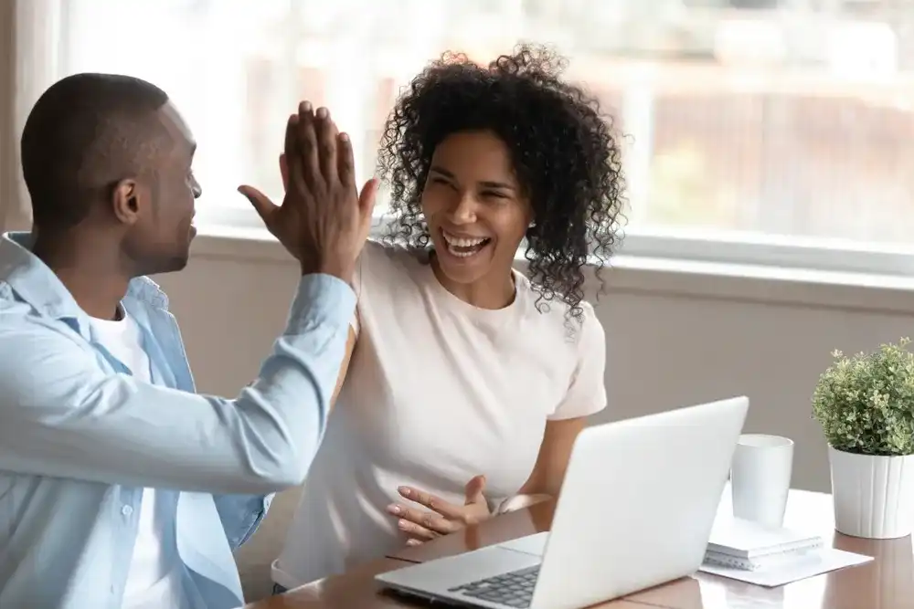 A couple celebrating getting their loan approved by a lender