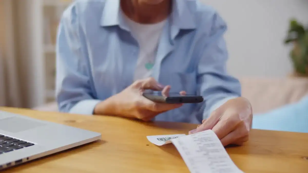 Person reviewing their grocery receipt for potential savings