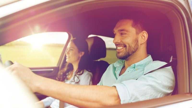 Man and woman driving in the new car they purchase with installment loan 