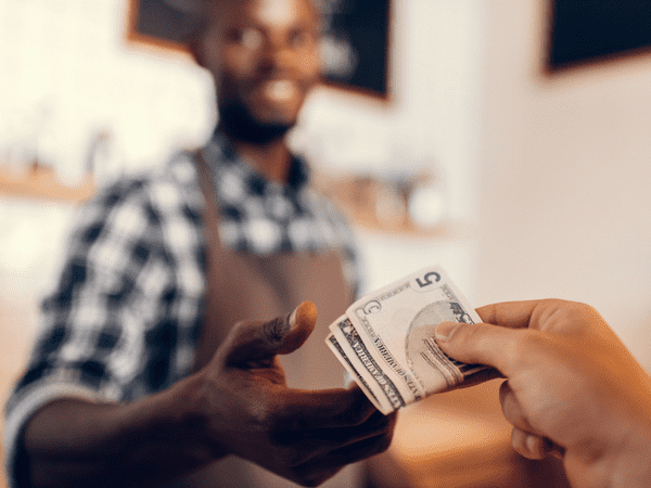 Person paying a cashier with cash from a cash advance 