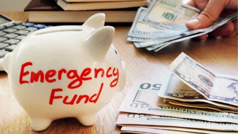 piggy bank with emergency fund written on it with cash 