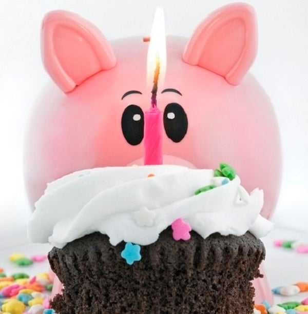 Piggy bank with a chocolate cupcake and a candle