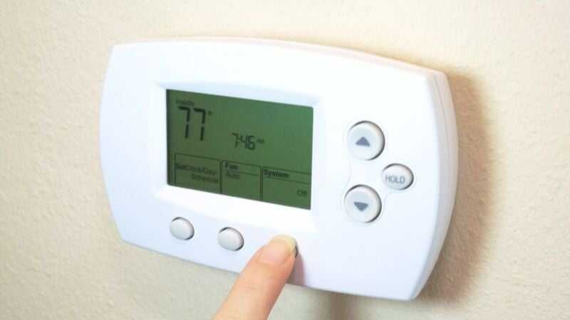 Person adjusting the thermostat