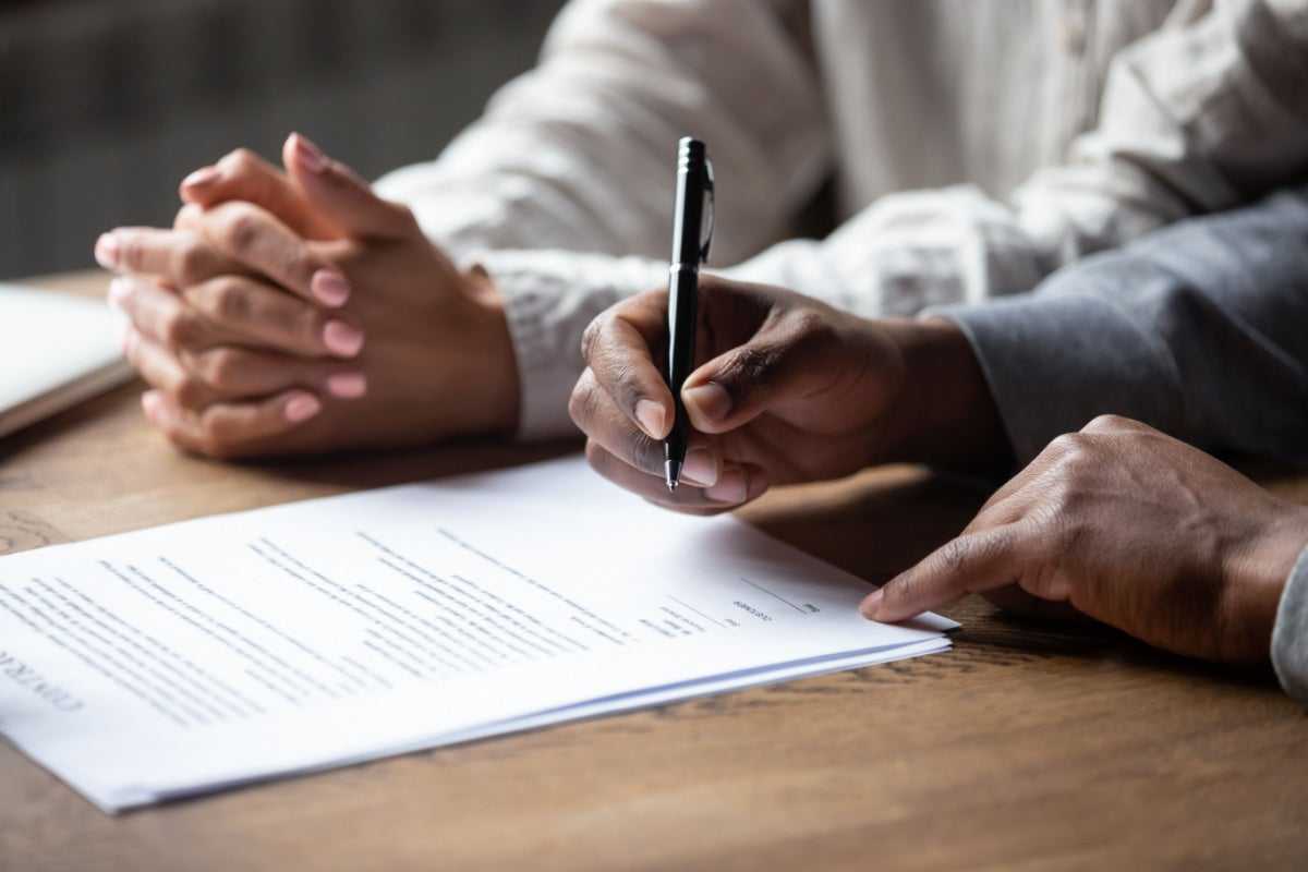 Someone signing a title loan, which can provide you with access to cash quickly, often within 24 hours