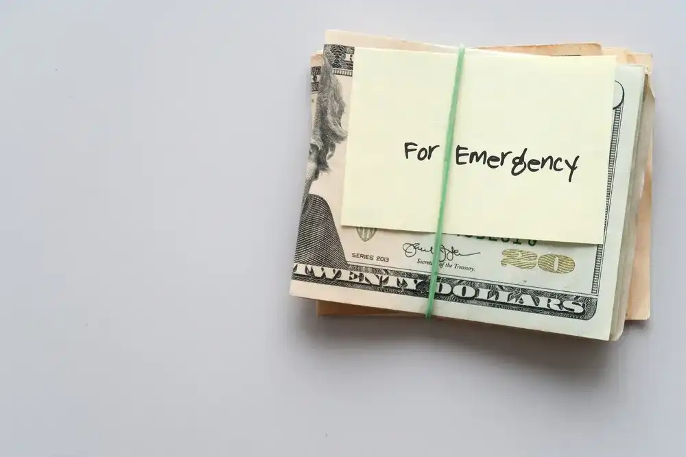 A wad of $20 bills with a note reading "For Emergency"