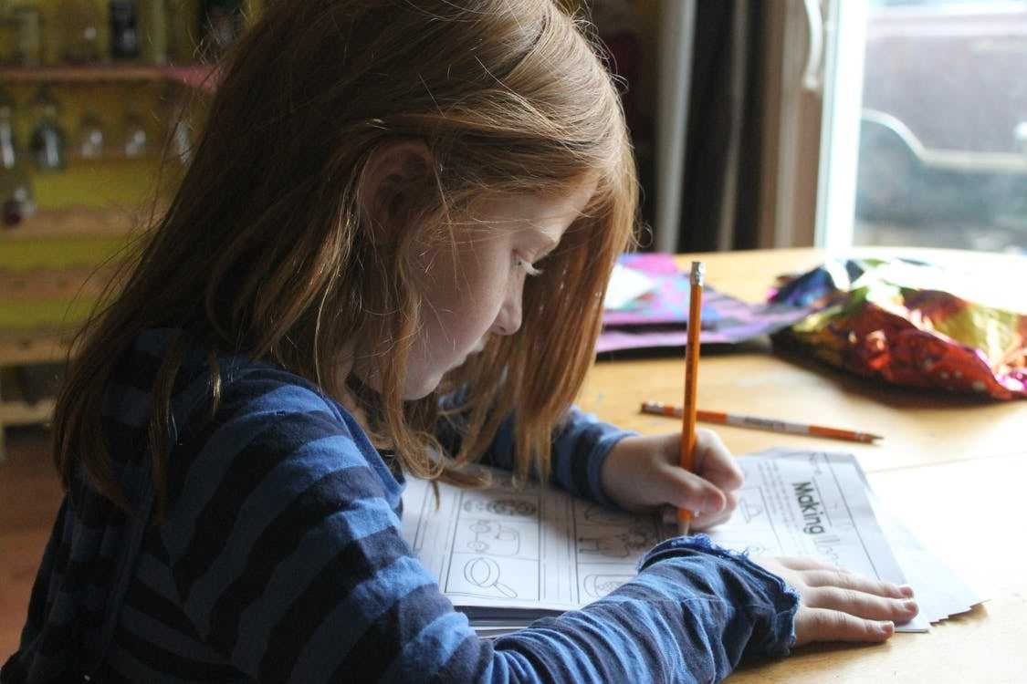 A little girl doing her homework at home.