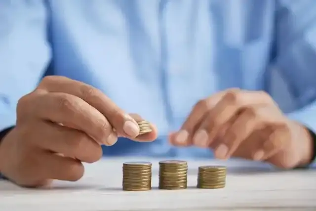 Person stacking change representing navigating tax season
