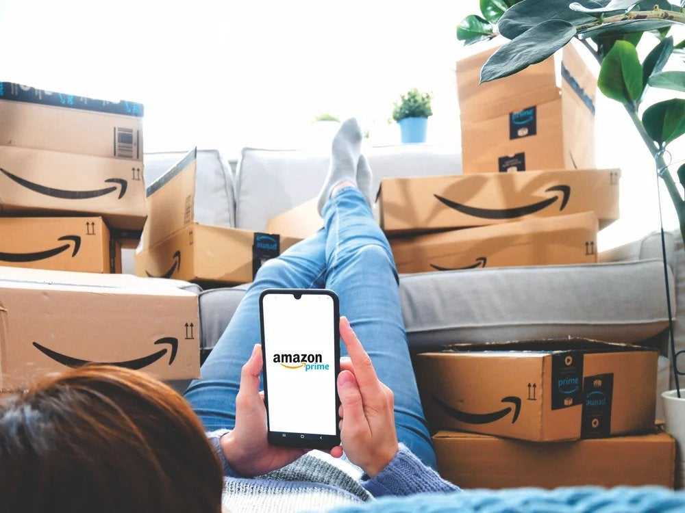 A person surrounded by Amazon boxes after shopping on a Prime day
