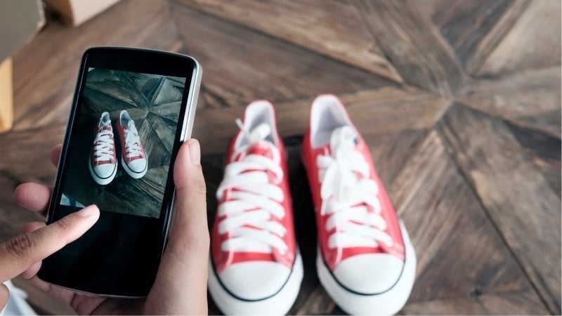 Person taking a picture of their shoes to sell online