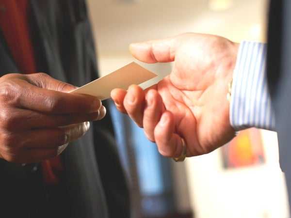 Man handing another man his business card 