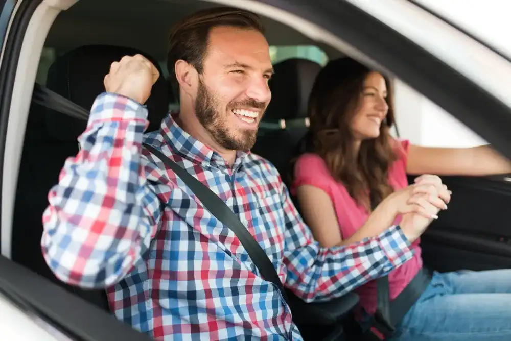 A couple celebrating getting a loan using their car as collateral