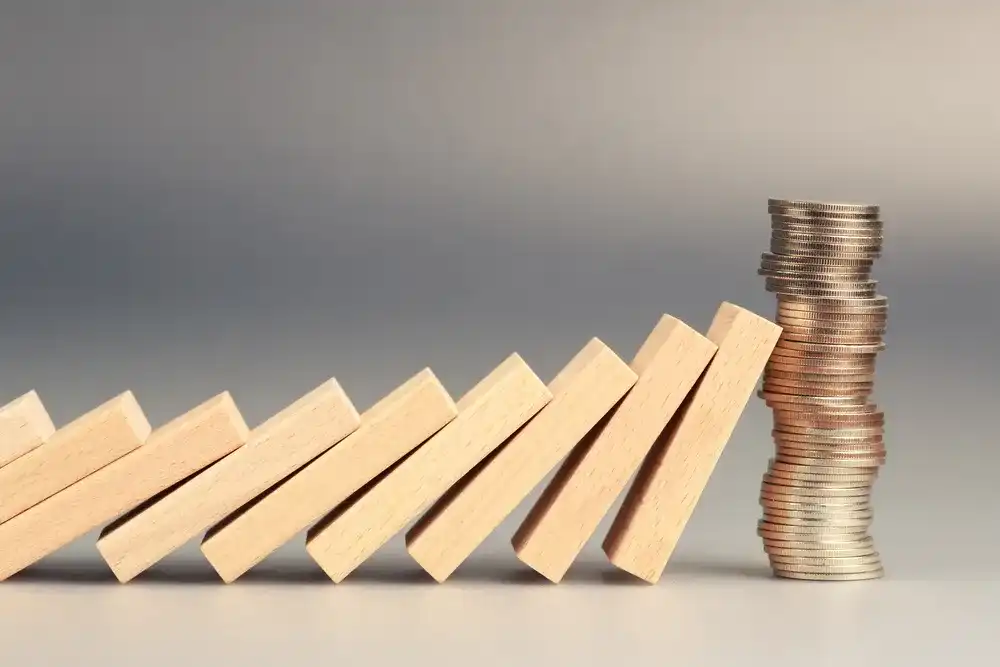 Wooden blocks falling into a stack of coins