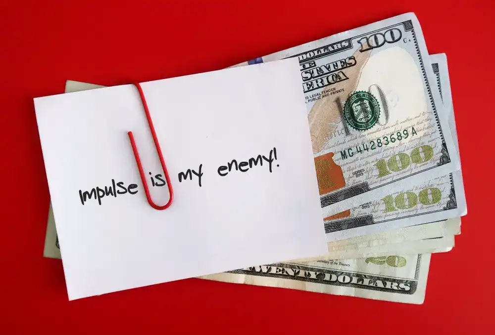 A wad of money with a note attached, reading "Impulse is my enemy!"